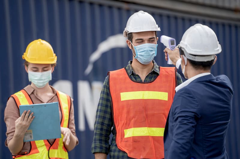 Encargado midiendo la temperatura a un trabajador para evitar el covid